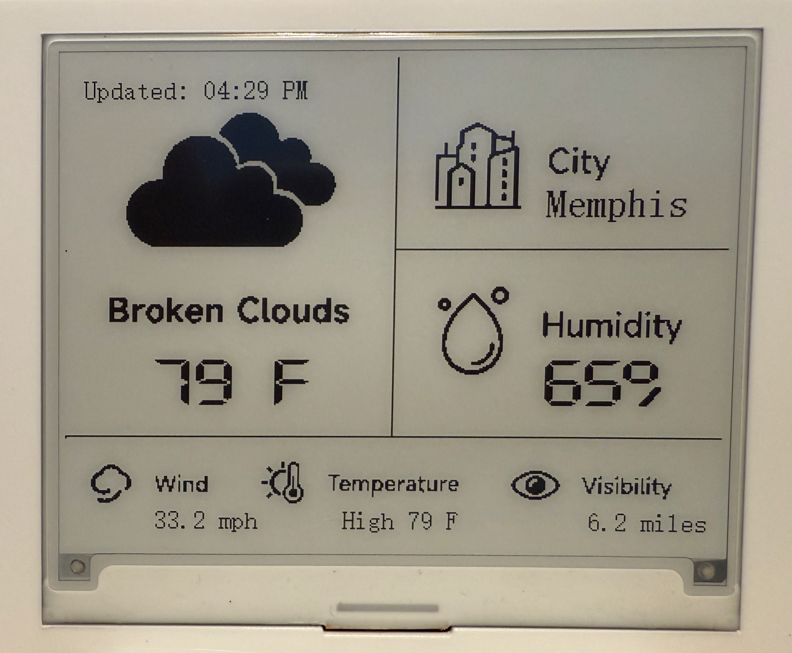 A photo of the finished CrowPanel ESP32 4.2-inch e-paper weather display mounted on a wall, showing the project’s actual screen with current temperature, humidity, wind, visibility, and update time in segmented black-and-white panels.